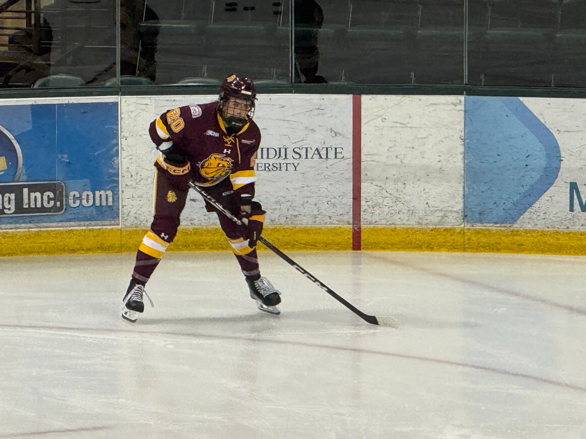 Lainey Gnetz playing hockey in maroon and gold